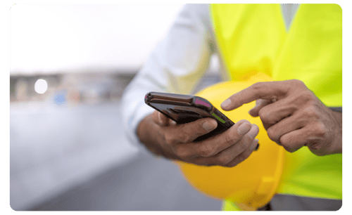 Male hands of a construction worker with mobile phone