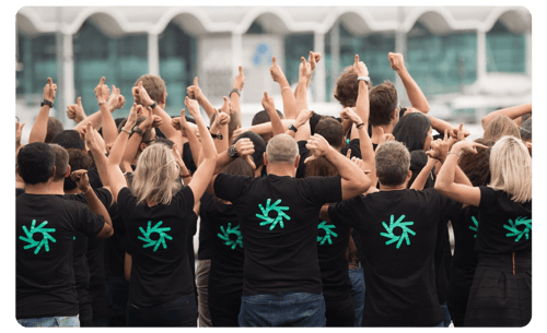 9Spokes team pointing to the backs of their tee with 9Spokes logo 9Spokes team pointing to the backs of their tee with 9Spokes logo